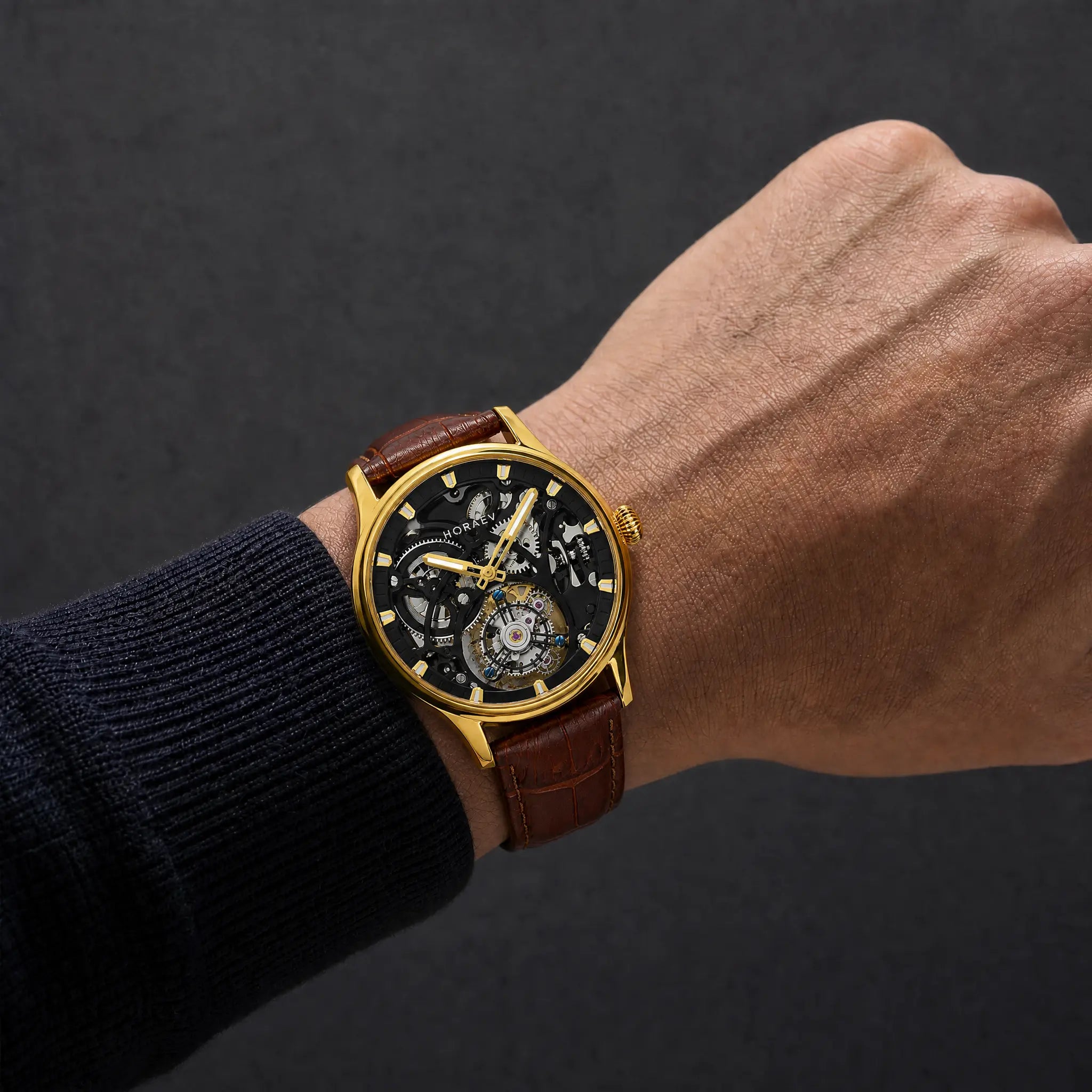 HOREAV gold skeleton mechanical watch worn on wrist with brown leather strap