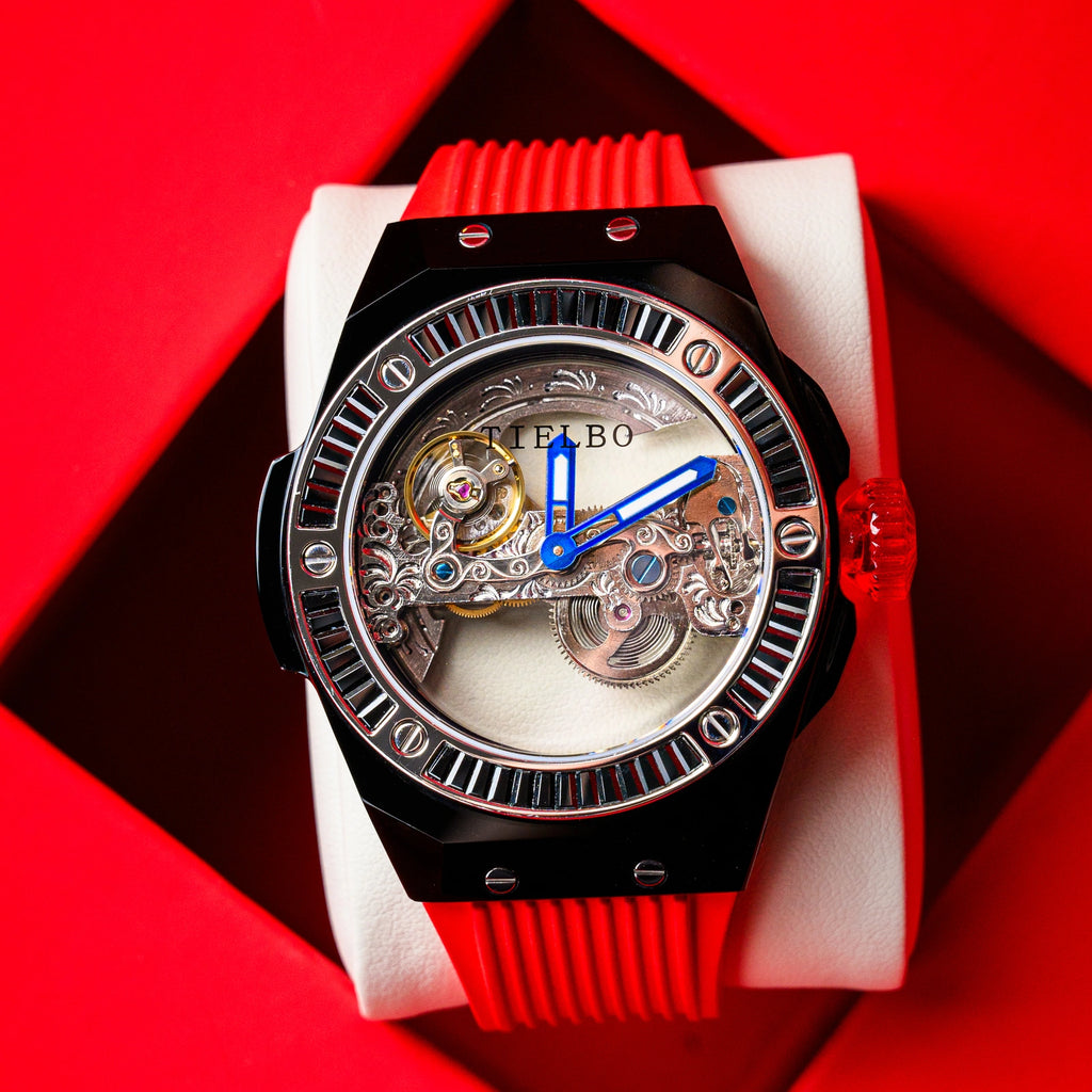 TIELBO T711 watch with black case, black bezel and red strap on a red display cushion; original product photograph.