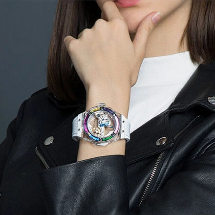 TIELBO T711 watch with clear case, rainbow bezel and white strap, worn with a black leather jacket.